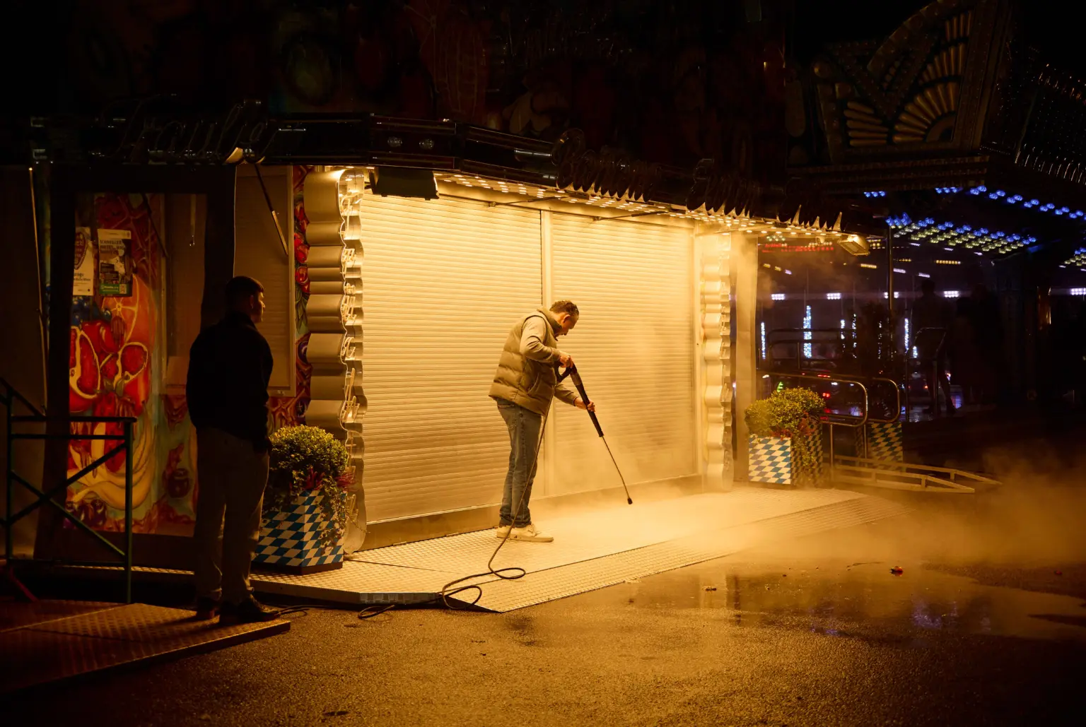 a men cleans the floor of a shack at oktobergest a night. after everyone has left the party.