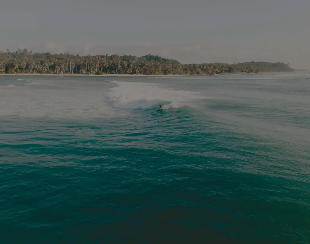 eine Surfer reitet eine riesige Welle in Indonesien